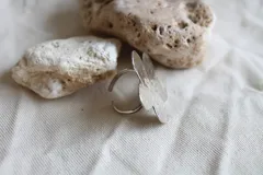Anillo plateado con forma de flor de hibisco y textura martillada.