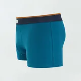 Pack de tres boxers de algodón elastizado, uno liso color celeste, uno con estampado geométrico azul oscuro sobre celeste y otro con estampado geométrico celeste sobre blanco. Todos tienen cintura elástica con logo de la marca.