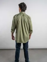 Camisa de corte regular, color terracota, de manga larga y diseño liso, con cuello camisero y cierre frontal de botones.