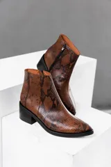 Botas cortas de cuero vacuno con estampado de piel de serpiente en tonos grises y blancos, con cierre lateral YKK, taco de madera foliado en cuero de 5 cm y caña de 12 cm.