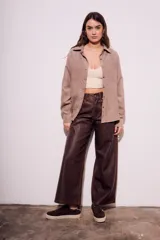 Camisa color marrón claro de gamuza vegana, corte oversize, con cuello clásico, cierre frontal con botones y mangas largas.