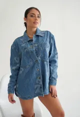 Campera de jean celeste con estampado de corazones y números en tono más claro, corte holgado, cuello camisero, cierre con botones y bolsillos en el pecho.