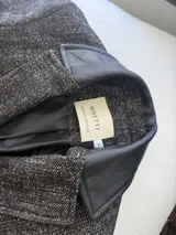Tapado de lana color bordó con solapas y detalles en los bolsillos de cuero. Presenta cierre frontal con botones y diseño de líneas clásicas.