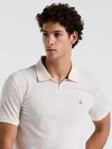 Polo de hombre color crudo con textura jacquard, cuello clásico con cierre de cremallera corto y logo bordado en el pecho.