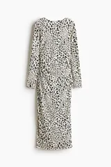 Vestido midi de punto entallado con estampado de leopardo, mangas largas y espalda abierta con detalle cruzado en la cintura.