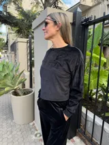 Conjunto de dos piezas confeccionado en tejido plush ultra suave, compuesto por un buzo cropped de corte relajado y un pantalón recto con bolsillos funcionales.
