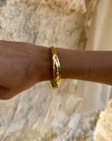 Esclava rígida de diseño artesanal con textura irregular y acabado metálico, ideal para uso diario.