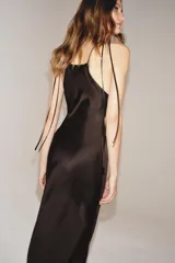 Vestido midi de Zara Woman Collection confeccionado en tejido satinado color marrón chocolate. Presenta un diseño de cuello halter con tirantes finos ajustables mediante lazada en la espalda y una caída fluida.