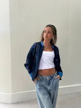 Campera azul marino con apliques de tela azul en los hombros y en el frente, con botones al frente y puños celeste.