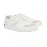 Championes Lacoste modelo L004, de diseño urbano en color blanco con detalles en gris claro. Presentan una silueta de perfil bajo con paneles de lona y refuerzos de gamuza en la puntera y el talón. Incluyen el icónico logo del cocodrilo metálico en el lateral del talón y una suela de goma vulcanizada.