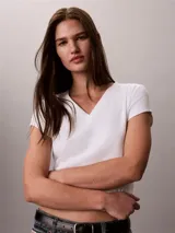 Remera de Calvin Klein Essentials confeccionada en punto de algodón elástico con textura de canalé. Presenta un diseño de corte slim, cuello en V, manga corta y una pequeña insignia con el logo de la marca en el bajo.