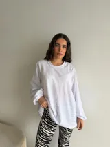 Buzo de viscosa y poliéster color blanco, de corte oversize, con mangas largas abullonadas y cuello redondo acanalado.
