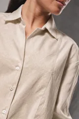 Camisa oversize de color celeste con un sutil diseño a rayas verticales blancas, manga larga y cuello camisero clásico.
