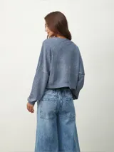 Buzo manga larga color celeste con diseño irregular y corte crop.