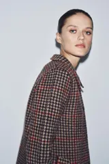 Abrigo de corte recto confeccionado en 100% lana, con estampado de pata de gallo en tonos tierra, negro y detalles en rojo. Presenta cuello solapa, cierre frontal con botones y bolsillos delanteros de vivo.