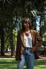 Blazer de corte sastrero con diseño de rayas verticales finas, solapas clásicas y bolsillos frontales con solapa. Presenta un calce holgado y estructura definida.