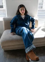 Jean de estilo recto y tiro medio-bajo confeccionado en denim azul marino oscuro. Presenta un diseño con costura vertical en la parte posterior de las piernas y bolsillos traseros clásicos. Esta prenda está elaborada con algodón reciclado bajo procesos de producción sostenible.