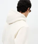 Buzo cerrado de fleece con capucha ajustable, manga larga con puños acanalados, bolsillo tipo canguro y cintura ajustada.