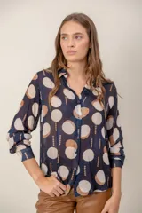 Camisa de manga larga con estampado de leopardo, cuello clásico y cierre frontal de botones. Presenta un corte holgado y puños abotonados.