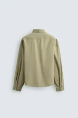 Camisa de corte boxy fit confeccionada en tejido de algodón con estampado de cuadros. Presenta cuello solapa, manga larga con puños abotonados, bolsillo plastrón en el pecho y cierre frontal de botones. Incluye un bordado a contraste en el pecho.