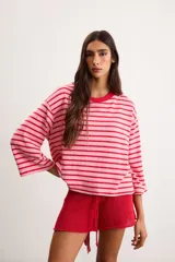 Remerón de algodón a rayas horizontales celestes y rojas, con silueta oversize, cuello redondo y mangas 3/4.