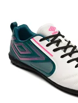Championes de fútbol Umbro modelo Vision TF, diseñados para césped sintético. Presentan una combinación de colores blanco, verde azulado y detalles en fucsia, con el logo de la marca en el lateral y suela de goma con tapones pequeños.