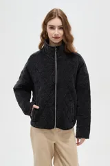 Campera de estilo bomber con diseño capitoneado en forma de rombos, color negro con efecto lavado. Presenta cuello alto, cierre frontal metálico y bolsillos laterales.