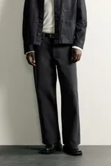 Jeans relaxed fit de corte recto y tiro medio, color negro, confeccionados en denim de algodón rígido con diseño de cinco bolsillos y cierre frontal de cremallera y botón.