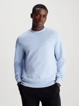 Buzo de cuello redondo Calvin Klein, confeccionado en mezcla de algodón y poliéster. Presenta un diseño de corte regular con puños y bajo de canalé, destacando un micrologo de la marca en contraste en el pecho.