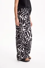 Pantalón ancho de lino con estampado en blanco y negro, cintura elástica con cordón de ajuste y bolsillos laterales.