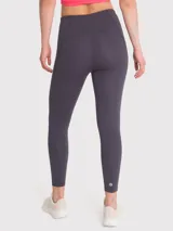Calza deportiva gris oscuro con tiro alto, bolsillos laterales y banda de silicona interna en la cintura. Confeccionada en poliéster y spandex con certificación Bluesign.