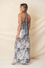 Vestido largo de brocato estampado en tonos gris claro y plata, con escote halter, falda drapeada con abertura lateral y forro interior.