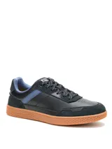 Sneakers de hombre Caterpillar modelo Pause Retro, color negro con detalles en azul y suela de goma color tostado. Confeccionados en cuero napa y gamuza, con cordones y suela texturizada con patrón de panal.