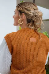 Chaleco tejido de punto calado en color lila, con cuello redondo y hombreras pequeñas. Presenta un diseño sin mangas y textura abierta.
