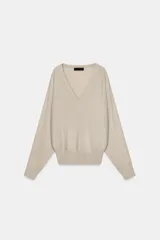 Jersey de lana color beige, con escote en pico y manga larga.