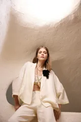 Saco de lino con fit amplio, solapa clásica, bolsillos falsos y mangas de largo regular. Presenta un diseño minimalista y elegante, ideal para combinar en conjuntos formales o casuales.