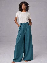 Pantalón de tiro alto confeccionado en lino, con corte de pierna ancha y calce relajado. Presenta pretina con presillas, cierre frontal con botón y tablas delanteras. Incluye bolsillos ojal en la parte trasera.
