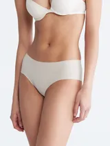 Bombacha hipster color beige de microfibra ligera con bordes cortados a láser y logo de Calvin Klein estampado en la cadera.