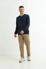 Sweater verde oscuro de tejido de punto, con escote en V y mangas largas.