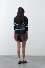 Short tipo skort de cuero sintético color marrón, con diseño envolvente y tiro medio.