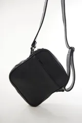 Morral bandolera de cuero genuino color marrón, con diseño compacto, cierre superior y correa ajustable para el hombro.
