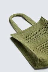 Bolso tipo shopper de diseño trenzado en color tostado, con estructura rectangular, dos asas de mano y compartimento principal abierto.
