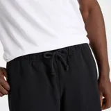 Short negro de felpa francesa con cintura elástica ajustable con cordón, bolsillos laterales con cierre y bolsillo trasero.