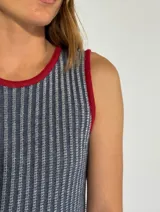 Vestido midi de punto con diseño a rayas verticales en tonos mostaza y blanco, con cuello redondo y sisas contrastadas en color bordó. Presenta aberturas laterales en el ruedo con detalles en color bordó.