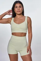 Conjunto deportivo compuesto por un top de escote redondo con logo estampado y un short de tiro alto con diseño ajustado.