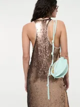 Vestido largo de corte recto con escote redondo y tirantes anchos, completamente cubierto de lentejuelas brillantes. Presenta tajos laterales en el ruedo.