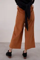 Pantalón marrón de pana con corte cropped y bolsillos frontales.