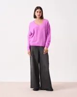 Sweater negro de silueta relajada con escote en V abierto, mangas largas y puños y ruedo cortos. Tejido extra suave tipo pelo.