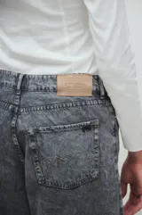 Pantalón de jean gris con efecto lavado, corte wide leg y tiro medio.