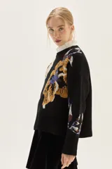 Sweater de cuello redondo con diseño de jacquard floral en cuerpo y mangas, confeccionado en tejido de punto con terminaciones acanaladas en puños y ruedo.